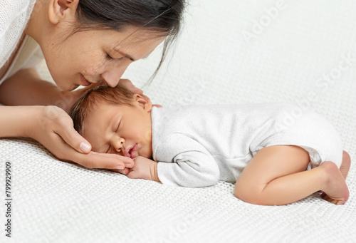 Baby Head in Mother Hands. Happy Mum holding Newborn sleeping on White Blanket. Child Birth and Development. Infant Health Care. Mother Love