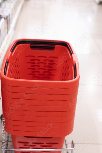 Shopping baskets nest to the shelves in a shop or supermarket, sale and promotion for food, product. Plastic container, supermarket or mall for retail, sales and trading