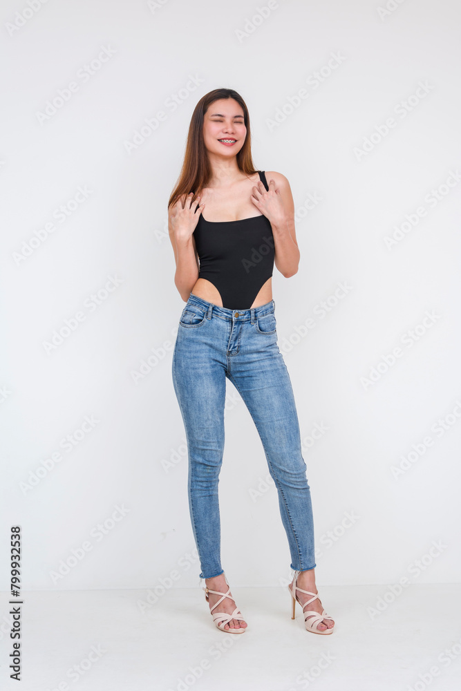 Young Asian woman in black bodysuit and jeans on white background Young Asian woman in black bodysuit and jeans on white background