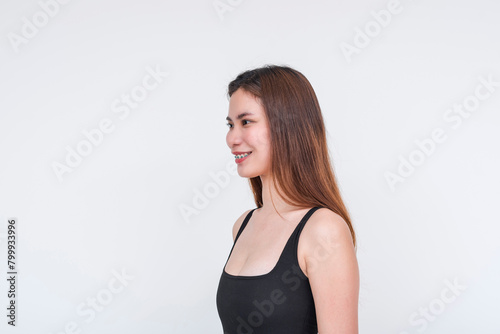 Elegant Asian woman in black bodysuit posing with a confident smile, isolated on white
