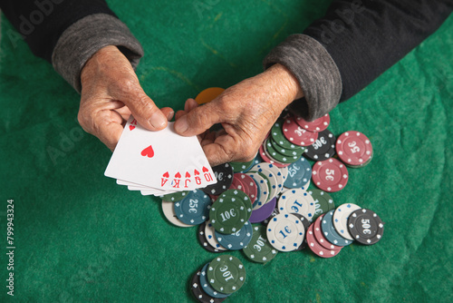 Elderly female hands holding casino games chips and cards. © andranik123