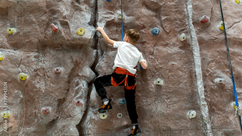 a boy or girl on a climbing wall climbs the wall of a climbing wall