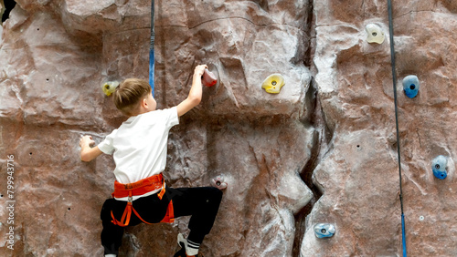 a boy or girl on a climbing wall climbs the wall of a climbing wall