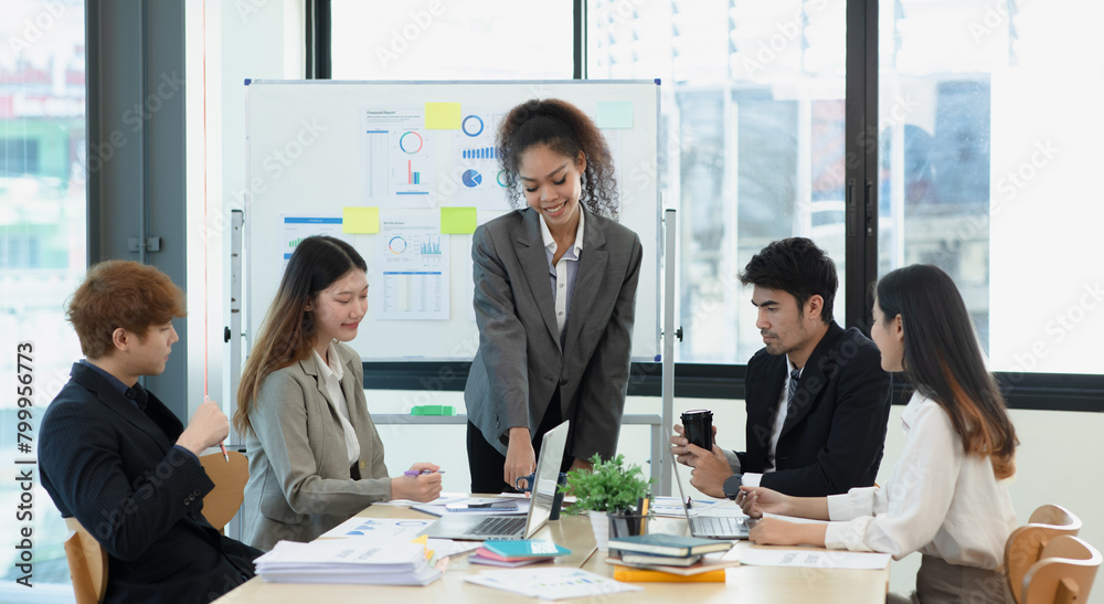 Asian group of people working with documents have financial or marketing charts on a board room table at a business presentation or seminar. Asian group of people working with documents have financial or marketing charts on a board room table at a business presentation or seminar.