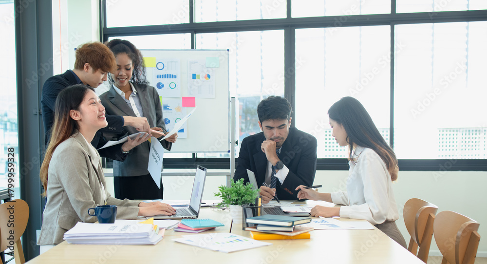 Asian group of people working with documents have financial or marketing charts on a board room table at a business presentation or seminar. Asian group of people working with documents have financial or marketing charts on a board room table at a business presentation or seminar.