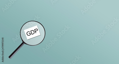 Business concept. There is a magnifying glass on the documents that points to the cubes with the inscription - GDP