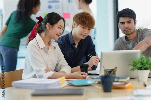 Asian group of people working with documents have financial or marketing charts on a board room table at a business presentation or seminar.