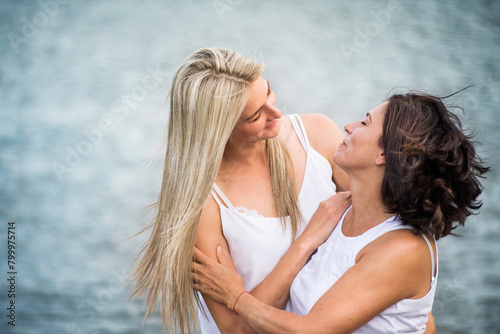 Adult daughter spending time with her mother outdoors. Beautiful daughter holding each other lovingly, hugging. Unconditional, deep maternal love, Mother's Day.