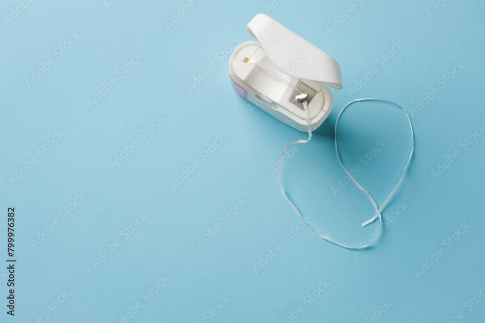 Fototapeta premium Top view of dental floss in white box on blue background