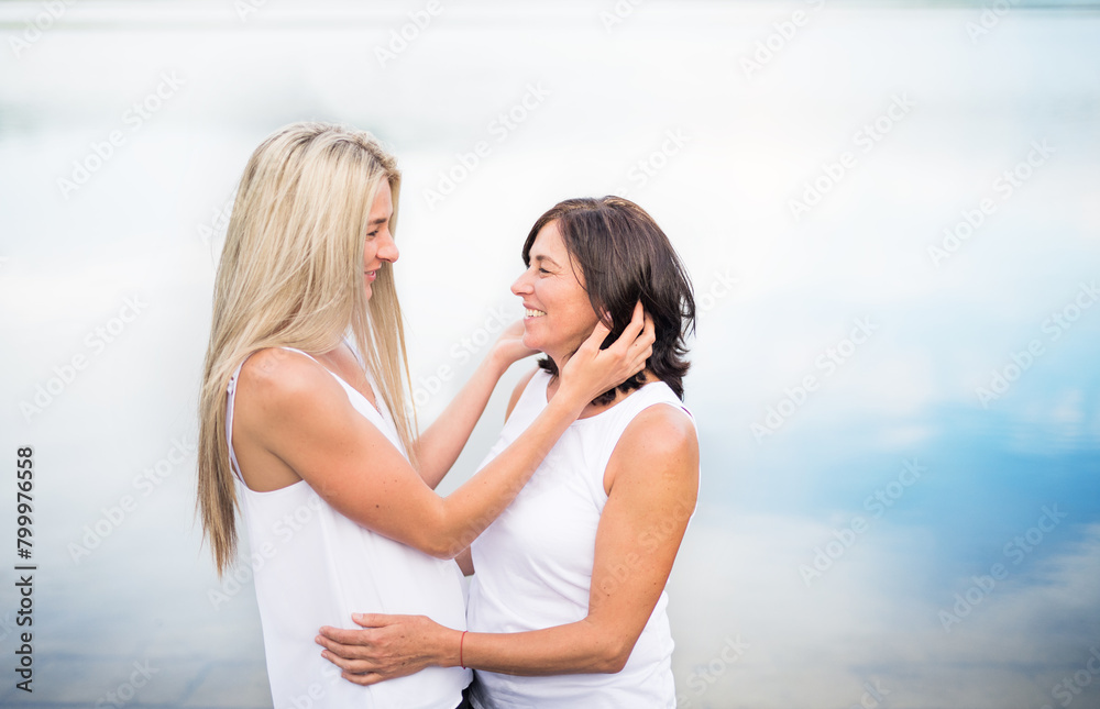 Adult daughter spending time with her mother outdoors. Beautiful daughter holding each other lovingly, hugging. Unconditional, deep maternal love, Mother's Day. Adult daughter spending time with her mother outdoors. Beautiful daughter holding each other lovingly, hugging. Unconditional, deep maternal love, Mother's Day.