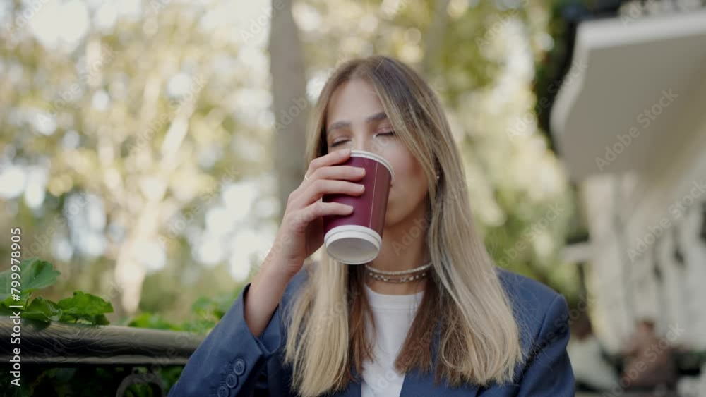 A stylish young woman sips coffee while seated outdoors. She portrays a relaxed, urban lifestyle with a confident, fashionable look. Young Professional Woman Enjoying Coffee Outdoors in the City A stylish young woman sips coffee while seated outdoors. She portrays a relaxed, urban lifestyle with a confident, fashionable look. Young Professional Woman Enjoying Coffee Outdoors in the City