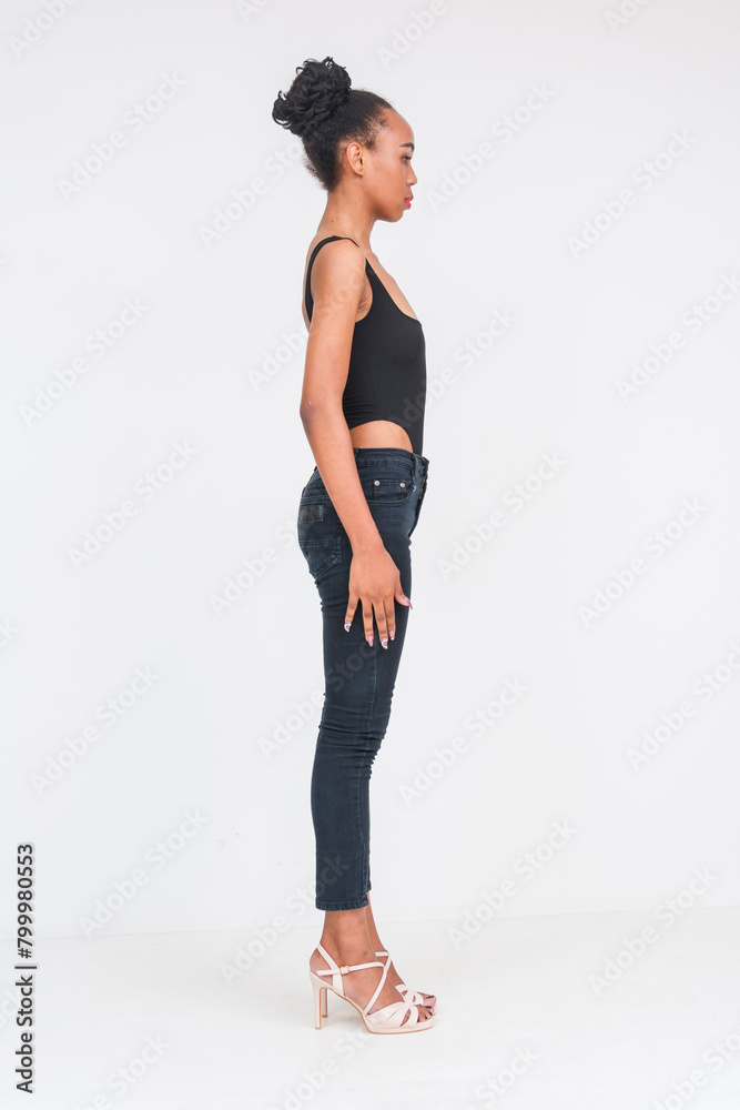 Stylish young woman in black bodysuit and jeans posing on white background Stylish young woman in black bodysuit and jeans posing on white background