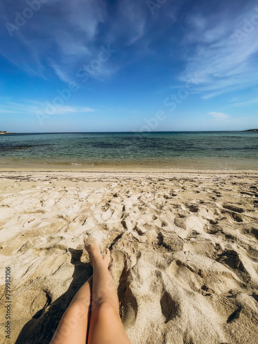 Women's feet on the sand, Corsica beach. France
