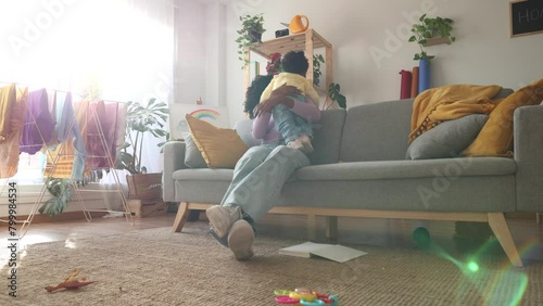 african american single mother with baby playing with messy house
