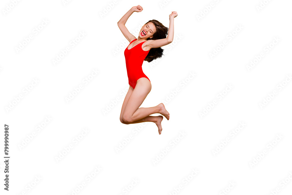 Finally, summer! Full-body portrait of crazy brunett girl in red body with closed eyes jumping clenching her hands in fists and joyfully screaming isolated on yellow background