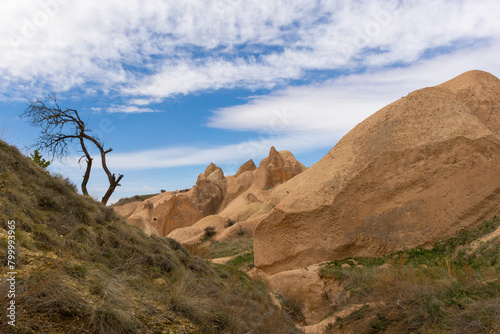 A view of brown, arid hills and mountains at the Cappadocia region under the cloudy sky © cemkurtulus