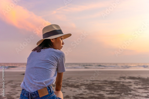 Sadly and depressed asian woman sitting on the beach near the sea alone. Bad feelings  through. Loneliness person. Depression Concept. Girl sit alone and think about her.