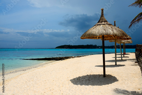 Blue Bay  Grand Port district  Mauritius  Africa - thatched parasols on idyllic sandy beach  Indian Ocean