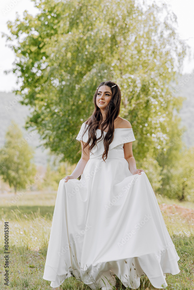 A woman in a white dress is standing in a field of grass A woman in a white dress is standing in a field of grass