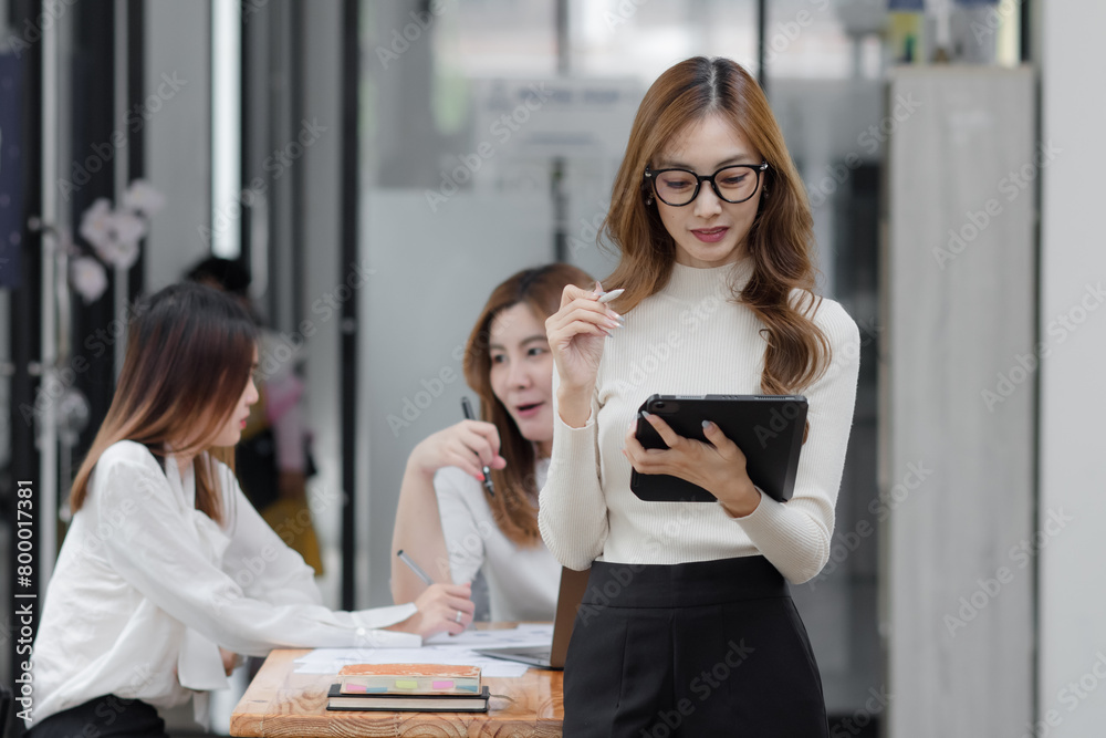 Group of young asian businesswoman working and brainstorming in workshop and analyzing marketing reports startup project infographics in the office. Group of young asian businesswoman working and brainstorming in workshop and analyzing marketing reports startup project infographics in the office.
