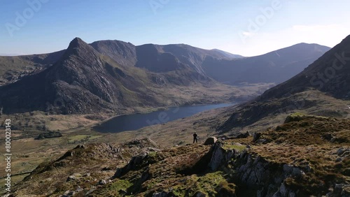 An aerial reveal of a man and tent on a beautiful mountain landscape in Snowdonia