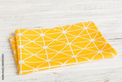 top view with yellow empty kitchen napkin isolated on table background. Folded cloth for mockup with copy space, Flat lay. Minimal style