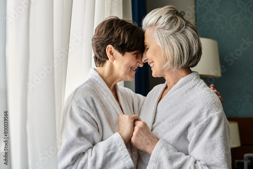 Tender senior lesbian couple standing together in a hotel.