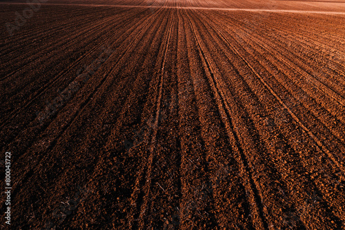 Aerial view of ploughed agricultural field with ridge and furrow pattern from drone pov
