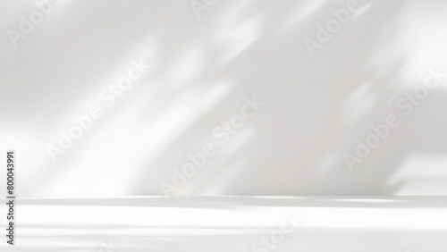 Minimal abstract light gray background for product presentation. Soft shadow and light from windows on white wall.