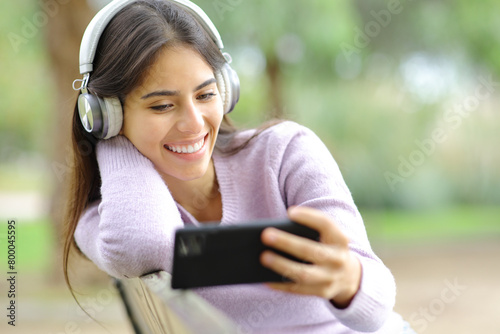 Happy woman watching streaming videos on phone
