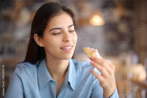 Woman in a restaurant eating bakery