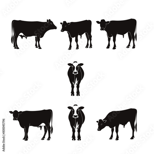 Solid black silhouettes of cows grazing, standing