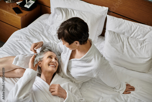 A peaceful scene of senior lesbian couple laying together in bed, sharing a tender moment of warmth and affection.