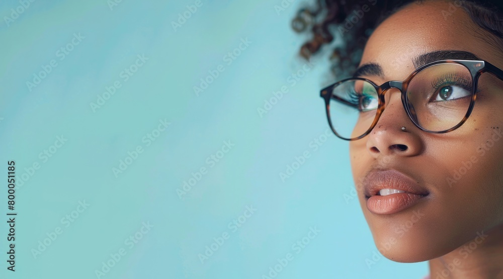 Close up of smiling African American woman wearing glasses and looking away, isolated on green background Close up of smiling African American woman wearing glasses and looking away, isolated on green background