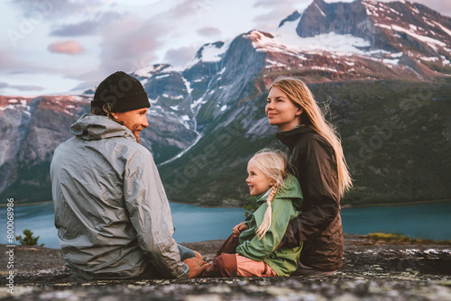 Family mother, father and child  traveling together in Norway summer vacations adventure camping outdoor hiking trip healthy lifestyle parents with kid daughter enjoying mountains and fjord landscape