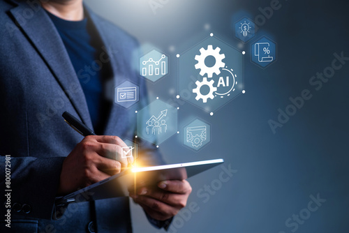 Business Automation and Artificial intelligence for business concept . Man using tablet and touch business automation icon on virtual display screen.