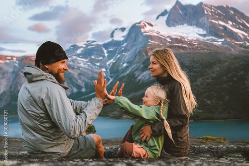 Family having fun outdoor traveling together in Norway mountains: mother, father and child on summer vacations hiking adventure trip healthy lifestyle parents playing with kid © EVERST
