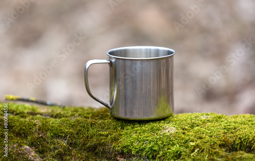 steel tourist mug on green moss © Pavlo Klymenko