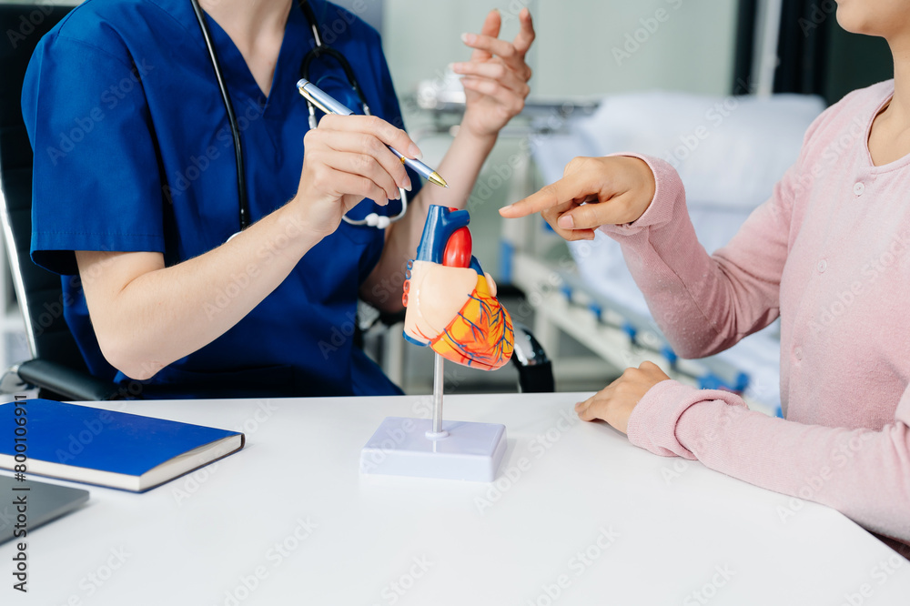 Doctor discussing treatment with Female patient talks to discuss results or symptoms and sitting on examination desk Doctor discussing treatment with Female patient talks to discuss results or symptoms and sitting on examination desk