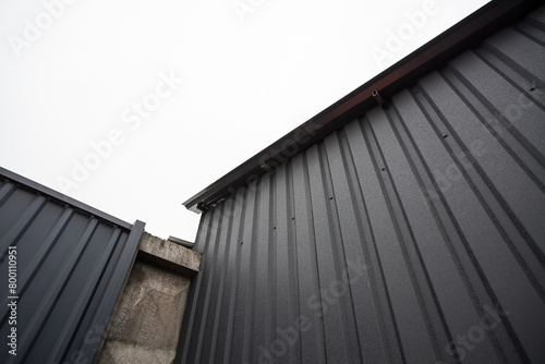 Geometric industrial dark composition of a concrete gray wall and an iron corrugated roof of a building, background for your design or illustrations.