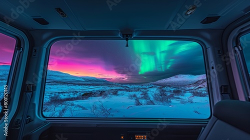 View from inside of a vintage camper van in wild snow field with beautiful aurora northern lights in night sky with snow forest in winter. © Joyce