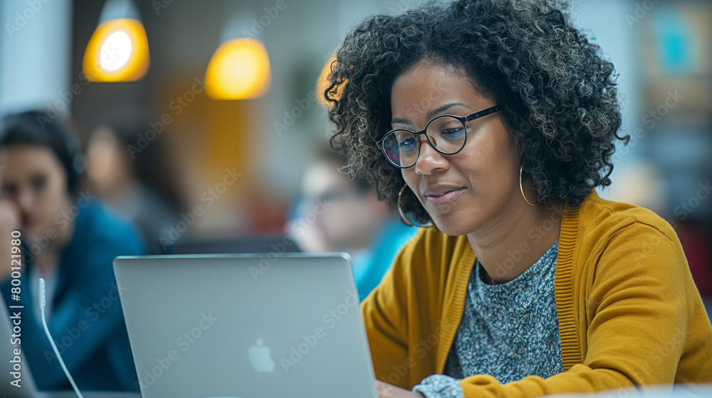 High school professor assists her students in e-learning on laptop in classroom.