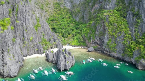 Aerial view of paradise cliffy island with white sand beach and exotic boats photo