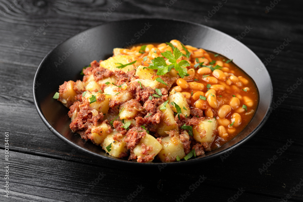 Corned beef hash with potatoes and beans in tomato sauce. Corned beef hash with potatoes and beans in tomato sauce.