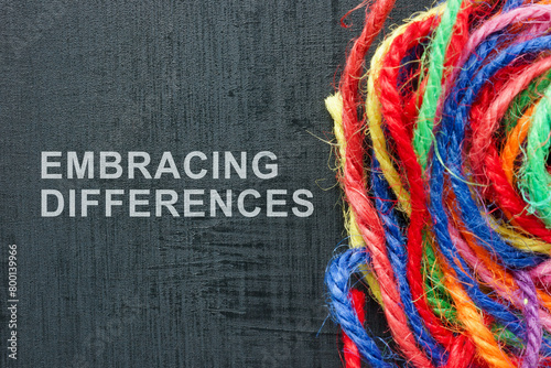 Words Embracing differences next to a ball of colored threads.