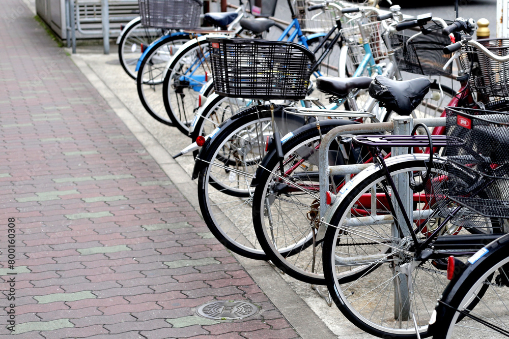 A group of bicycles lined up in a row on the sidewalk.