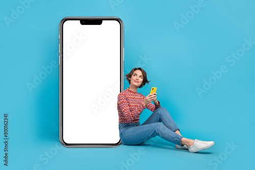 Full length photo of sweet thoughtful woman dressed print top typing modern device looking empty space isolated blue color background © deagreez
