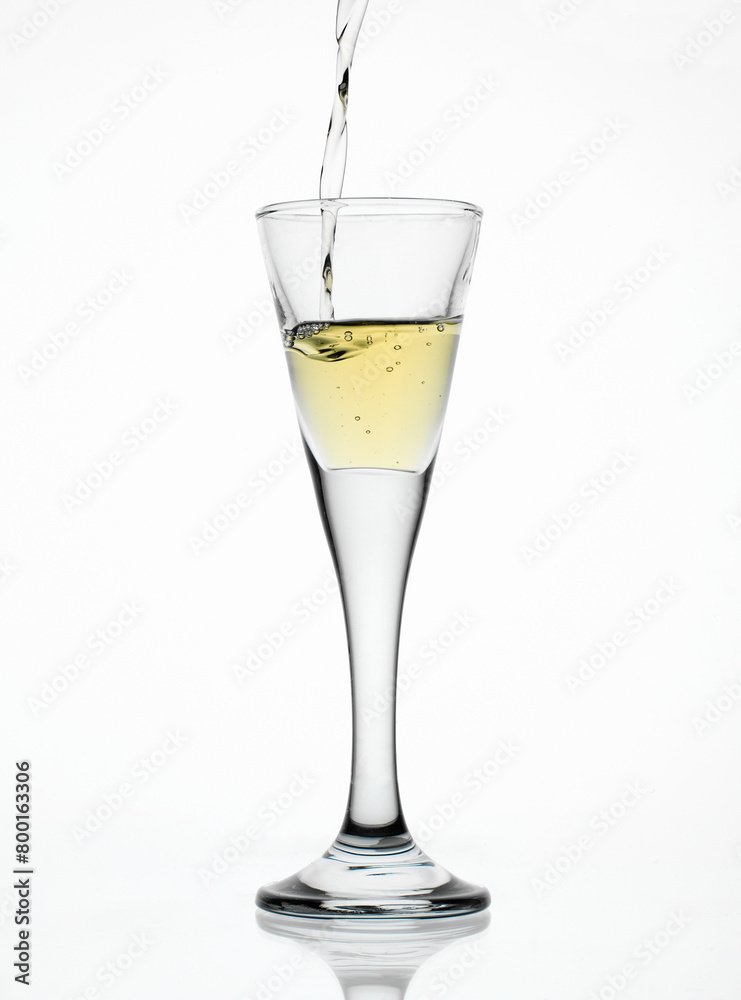 Aquavit pouring in a glass isolated on white background