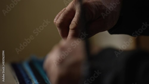 Person pushing and pulling zip tie into blue material photo