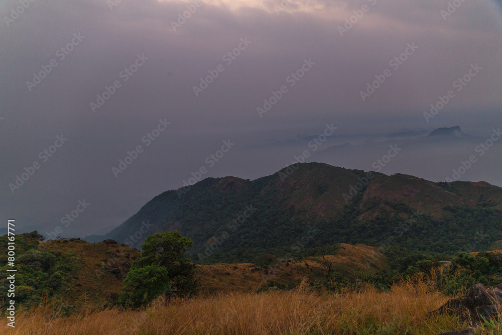 A mountain range with a cloudy sky in the background A mountain range with a cloudy sky in the background